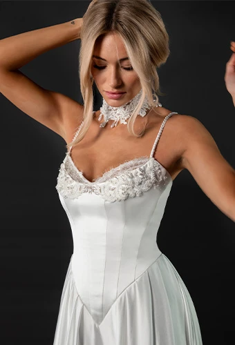 Bride wearing satin wedding dress with lace edges and thin spaghetti straps