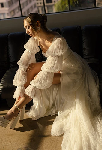 Bride wearing a line wedding gown with high leg slit and bubble sleeves