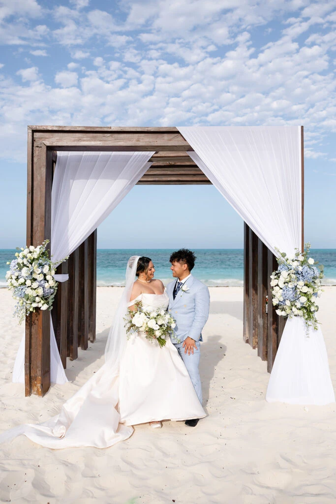 True bride Mariajose posing with her husband at the altar on the beach