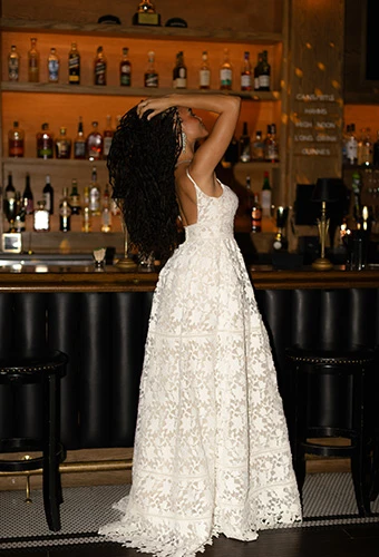 Bride wearing lace A-line wedding gown with graphic lace and court train, All Who Wander calla