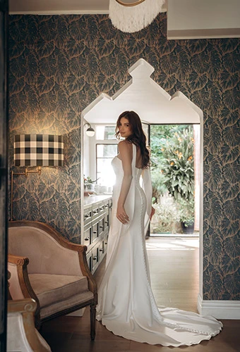 Bride wearing minimalist column wedding dress with chapel train, Stella York sy8347