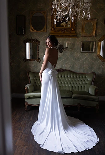 Bride wearing column wedding gown with open back and detachable bow train, Essense of Australia d4614