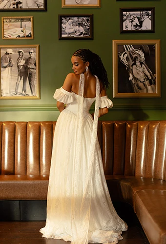 Bride wearing lace boho wedding dress with puff sleeves and court train, All Who Wander east