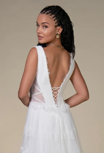 Bride wearing lace wedding dress with shoulder straps and corset back
