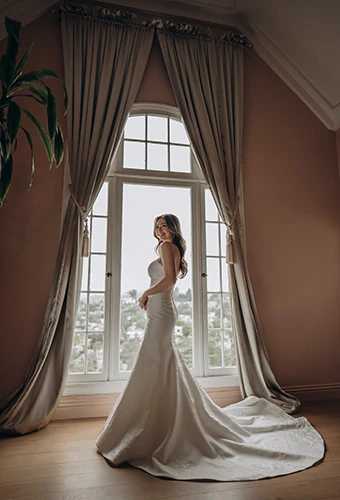 Bride wearing Mikado mermaid wedding dress with lace accents and chapel train, Stella York sy8251