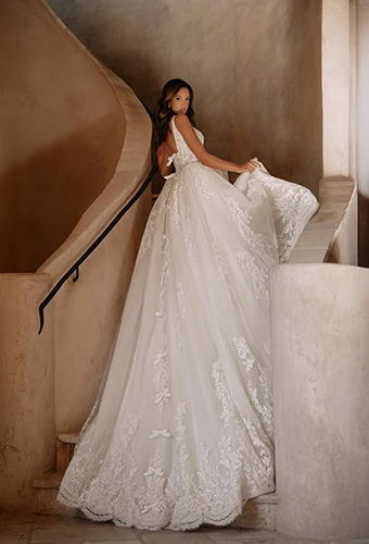 Bride wearing A-line wedding gown with lace-trimmed royal train finished with delicate bows, Martina Liana ml2041