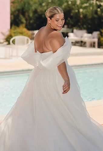 Plus size bride wearing a line wedding dress with off the shoulder straps