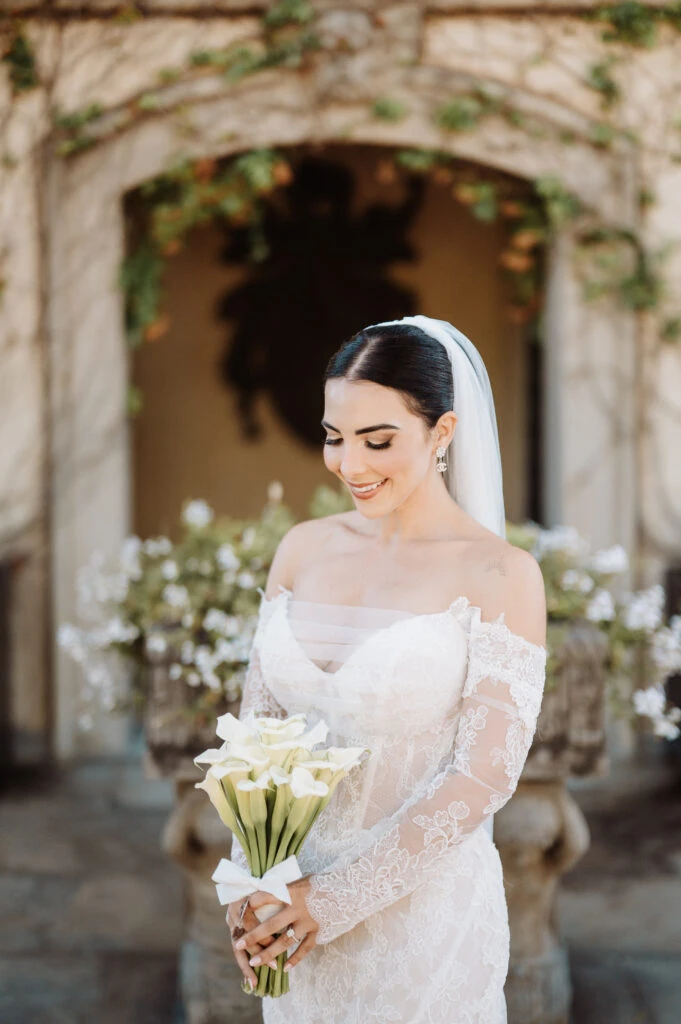 True bride Claudia posing in her wedding gown with bouquet