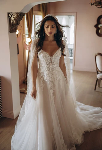 Bride wearing A-line wedding dress with shimmering beaded lace and tulle floral details, Stella York SY8293