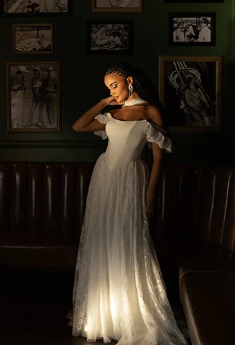 Bride wearing lace and crepe A-line wedding dress with puff sleeves and basque waistline, All Who Wander east