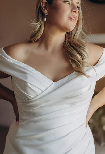 Close up of bride wearing crepe wedding dress with off-shoulder straps, Stella York SY8330+