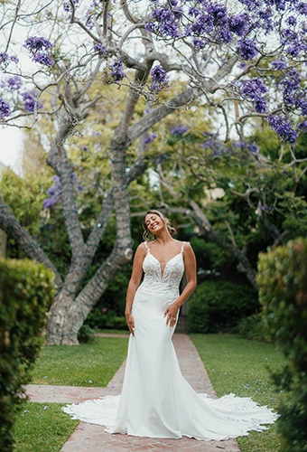 Bride wearing crepe fit-and-flare wedding dress with lace motifs and cutouts, Essense of Australia D3930