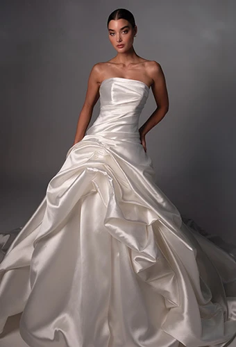 Bride waring strapless wedding gown with straight across neckline and draping