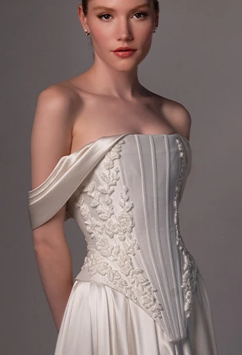 Bride wearing faux two piece wedding gown withoff the shoulder straps and straight across neckline