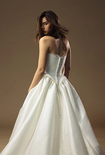 Bride wearing strapless a line wedding dress with fabric covered buttons
