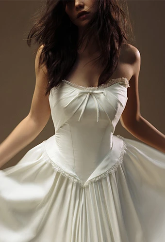 Bride wearing strapless wedding gown with straight across neckline and bow detail