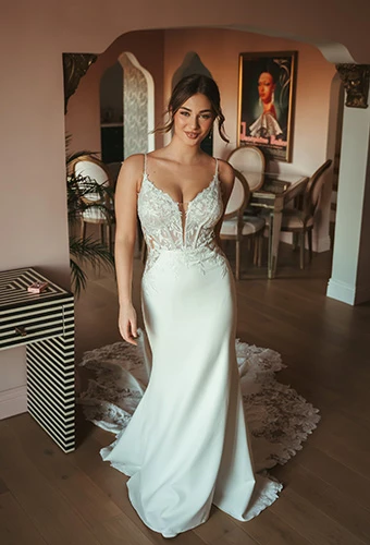 Bride wearing sheath wedding dress in crepe and lace with plunging neckline, Stella York SY8340