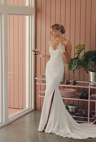 Bride wearing simple crepe wedding dress with draped neckline and ruched bodice, Stella York SY8224