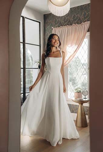 Bride wearing simple crepe A-line wedding dress with square neckline and thick straps, Stella York SY8257